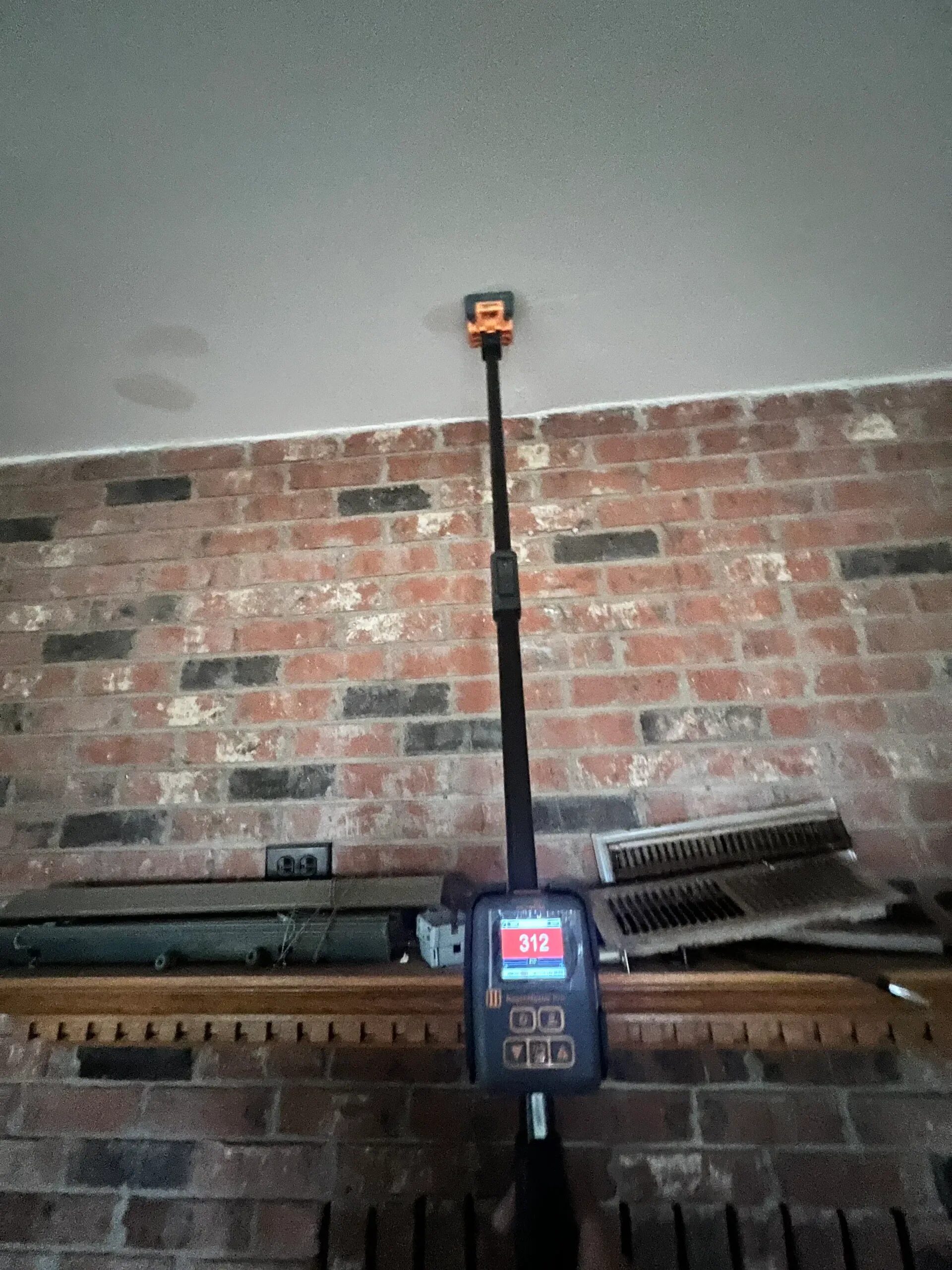 Moisture meter testing an interior ceiling during a moisture assessment